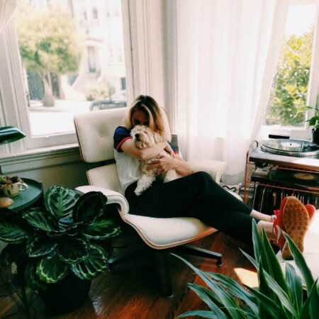a woman sitting on a couch with a dog