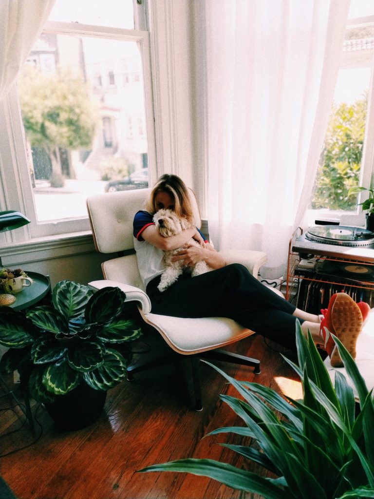 a woman sitting on a couch with a dog