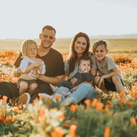 a family sitting in a field of flowers