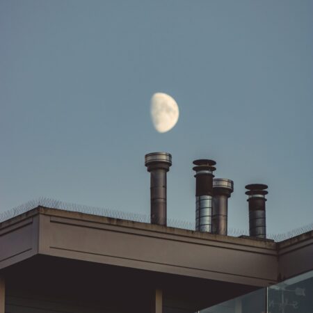 a moon over a rooftop