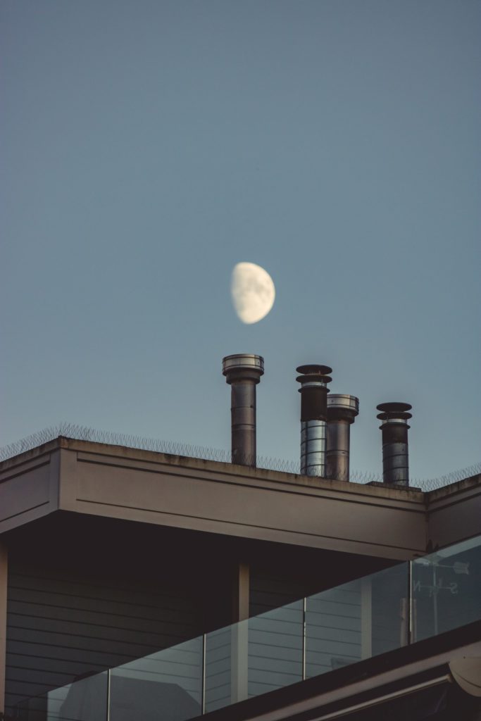 a moon over a rooftop